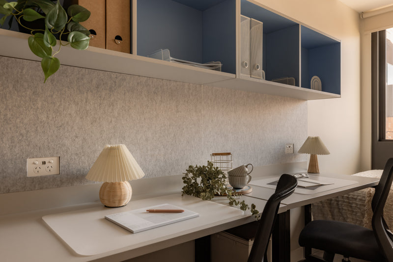 Modern kitchen with white countertops, blue cabinets, and decorative elements.