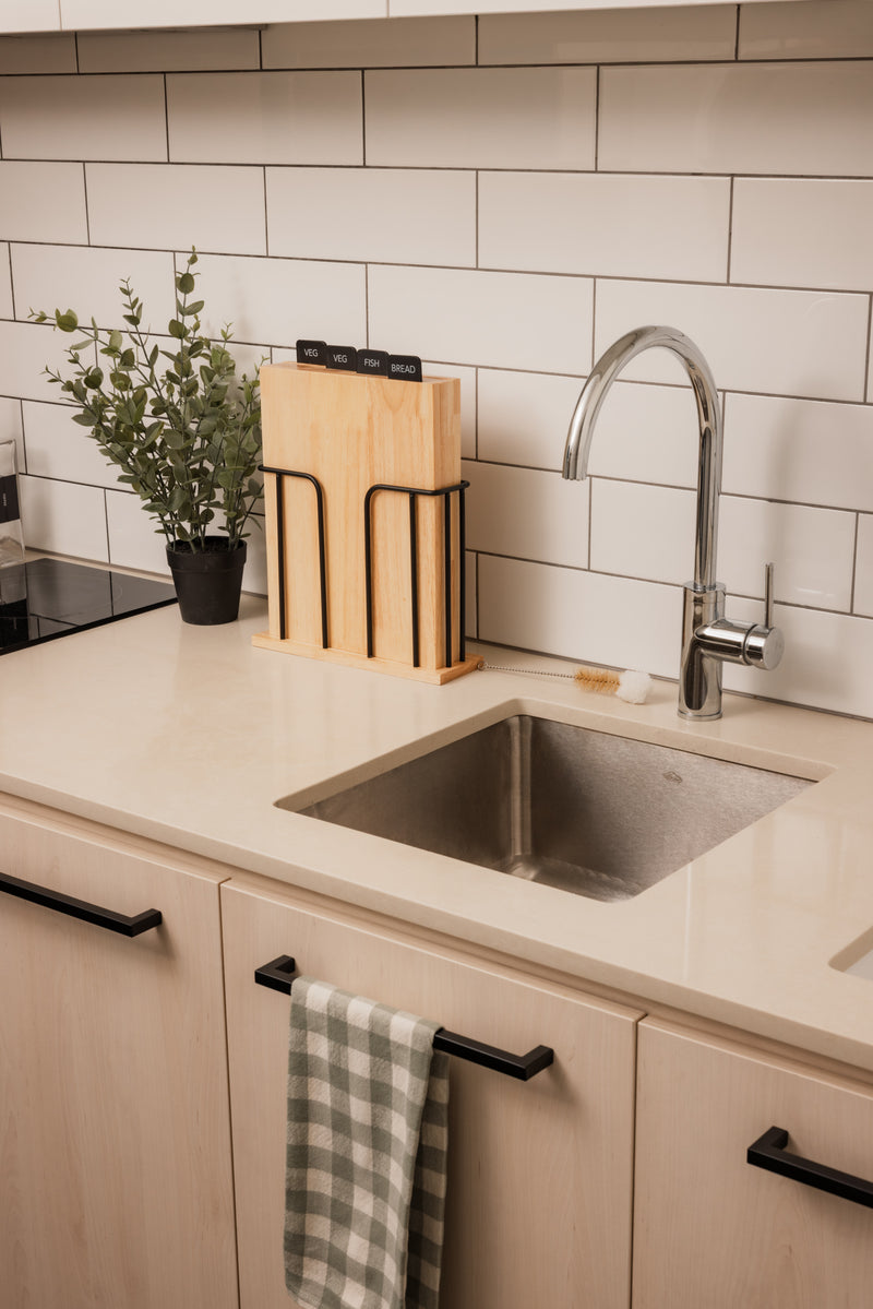 Modern kitchen with sink, countertop, and tiled wall.