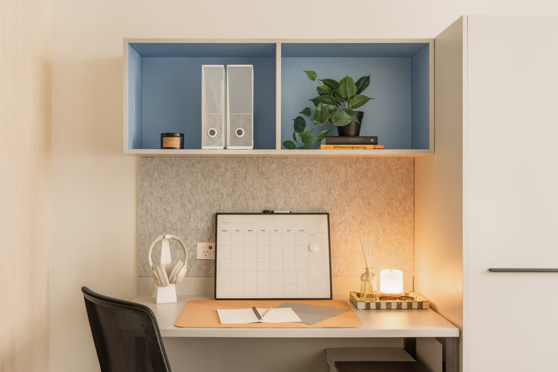 Modern home office with a desk, chair, and shelves.