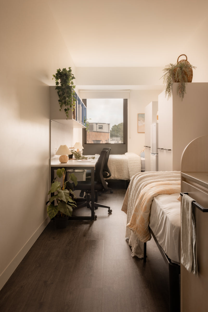 Small bedroom with desk, bed, and window view